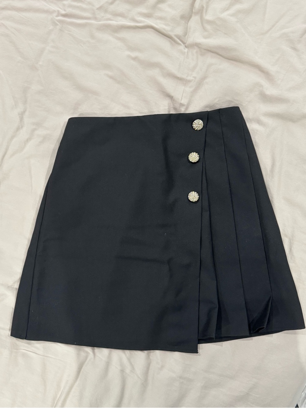 Black Mini Skirt with Side Pleats and Decorative Buttons